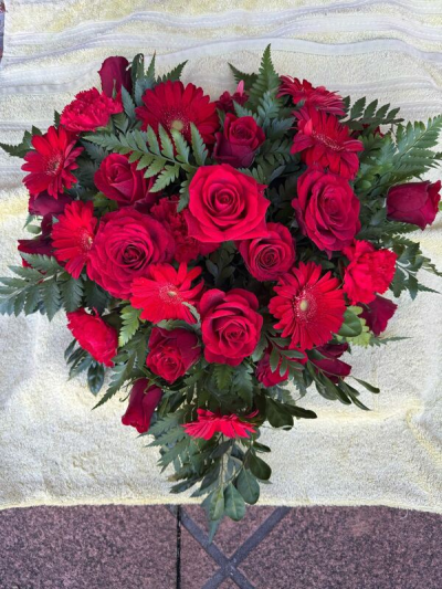 Heart - A striking heart-shaped tribute designed in rich crimson tones and surrounded by lush greenery. Carefully arranged to create a full, elegant display, this heartfelt design conveys love, admiration, and remembrance with timeless beauty. Suitable for commemorating a cherished life, expressing deep affection, or marking a meaningful occasion with grace and sincerity.